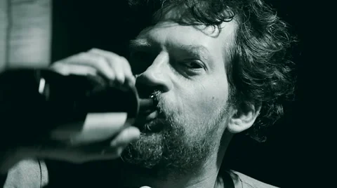 Drunk man drinking from wine bottle black and white Stock Footage 59805736