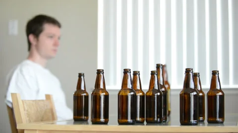 Drunk man leaves table of empty beer bottles Stock Footage 39505569