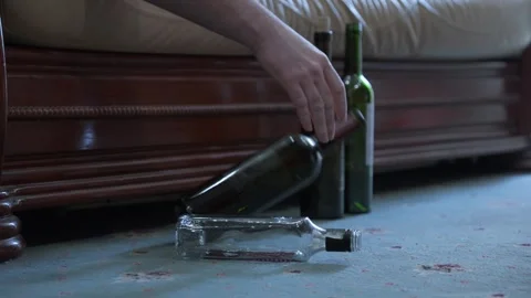 Drunk man lies on sofa with wine bottle in his hand. Problem of binge drink.. Stock Footage 266788771