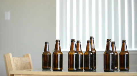Drunk man looks for more beer in empty bottles Stock Footage 39505584