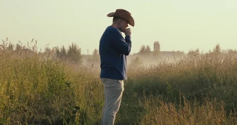 Drunk man or under influence of drugs is standing in field and smoking cigarette Stock Footage 158680434