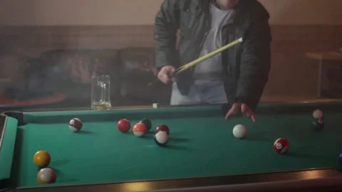 Drunk man playing billiards and drinking beer Stock Footage 83136908