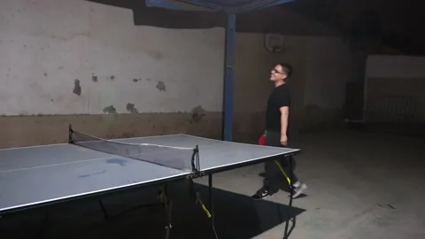 A drunk man playing ping pong at a night party Stock Footage 170013660