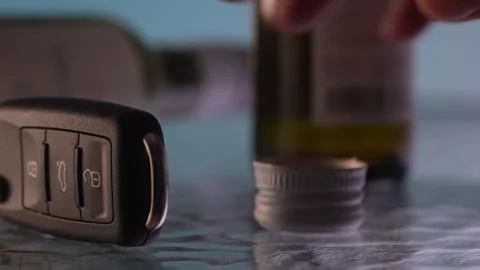 Drunk man puts an empty bottle and takes the car keys. Stock Footage 261985223