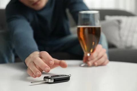 Drunk man reaching for car keys indoors, closeup. Don't drink and drive conce Stock Photos