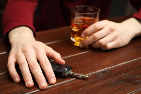 Drunk man reaching for car keys at table, closeup. Don't drink and drive co.. Stock Photos