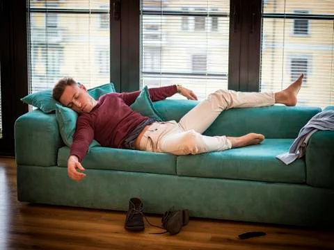 Drunk Man Resting on Couch with head on the Floor Stock-Fotos