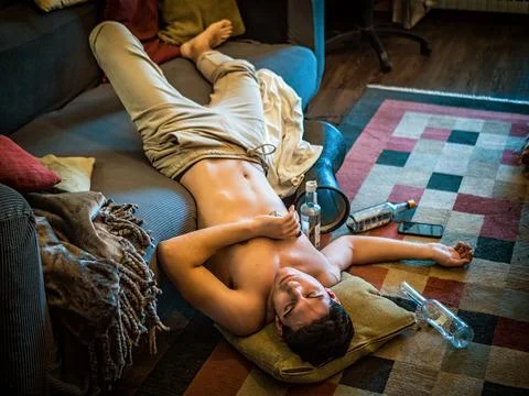 Drunk Man Resting on Couch with head on the Floor Stock Photos