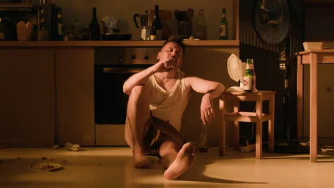 Drunk Man Sitting on Floor Struggling with Alcohol Addiction at Home Stock Footage 344876507