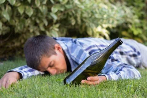 Drunk man sleeping in the park after the party. the problem of  alcoholism. Stock Photos