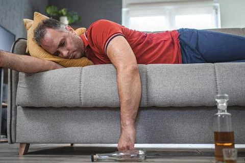 Drunk man sleeping on a sofa Stock Photos