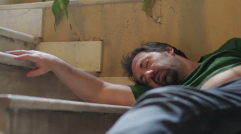 Drunk man sleeping on a staircase Stock Footage 32356191
