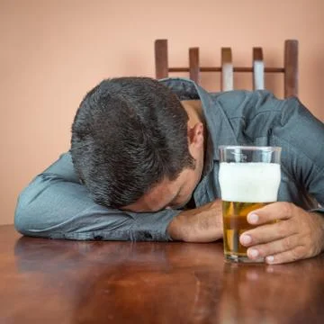 Drunk man sleeping on a table Stock Photos