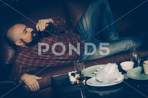Drunk man on the sofa. Alcoholism, alcohol addiction, drug addic Stock Photos