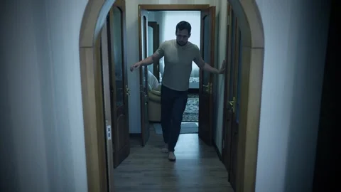 Drunk man staggers down hallway holding walls Stock Footage 340093886