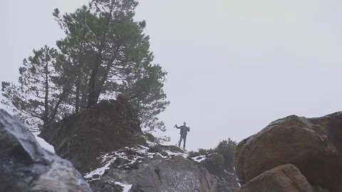 A drunk man stands on a rock with a bottle of wine and dances Stock Footage 84923108
