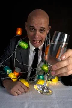 A drunk man with a string of lights around him holding a glass of champagne Stock Photos