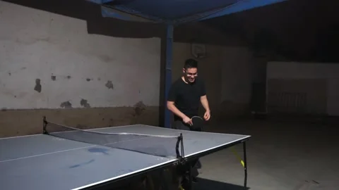 A drunk man warming up to play ping pong at a night party Stock-Footage 170013653