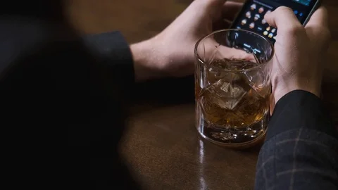 Drunk man writes message in phone, sends hearts,concept of alcoholic recreation Stock Footage 129802065