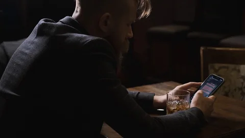 Drunk man writes message in phone, sends hearts,concept of alcoholic recreation Stock Footage 129802172