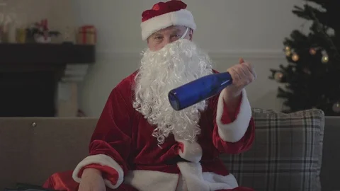 Drunk old man with false beard crooked on the face in the costume of Santa Claus Stock Footage 120912338