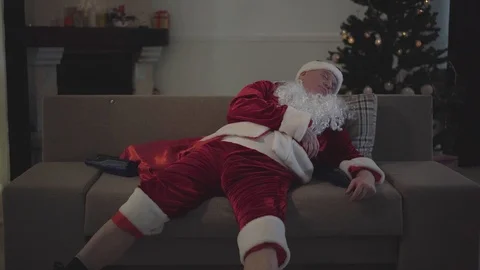Drunk old man with false white beard in the costume of Santa Claus sleeping on Video stock 120912252