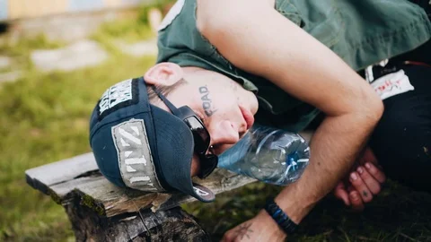 Drunk punk sleeping on a bench in the open air Close-up. Party animal. Stock Footage 115405751