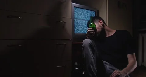 Drunk white male in his 30s-40s sits on the floor Stock Footage 201588024