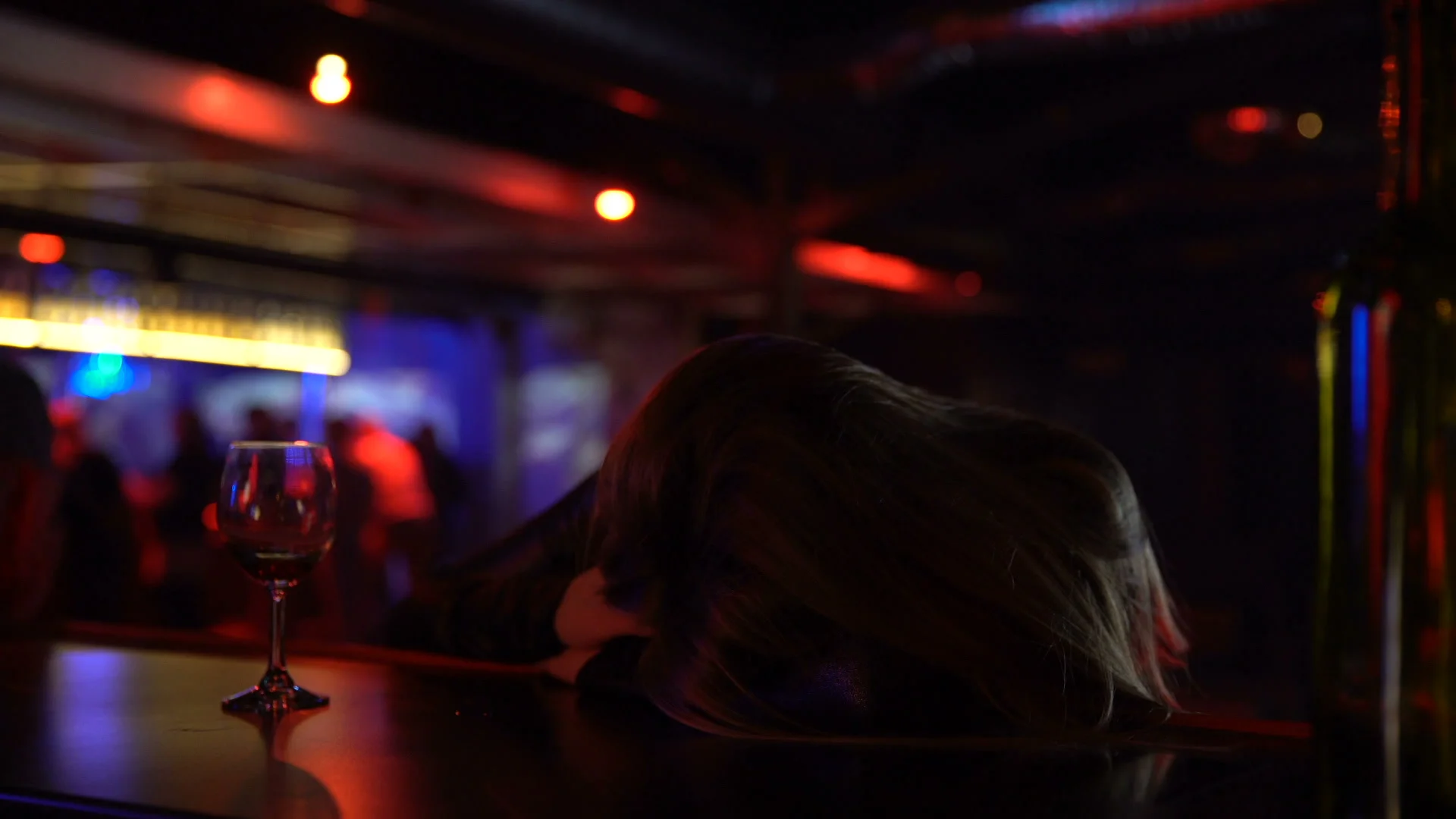 Drunk woman sleeping unconscious on bar counter, alcohol abuse, loneliness