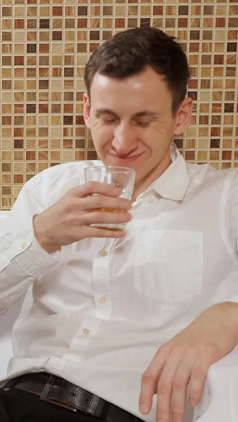 Drunk young businessman drinking whiskey and falling asleep after a party, young Stock Footage 344824075