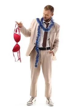 Drunk young man with bra after party on white background Stock Photos