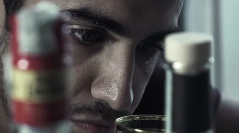 Drunk young man looks into the void in the middle of empty bottles Stock Footage 68939157