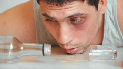 Drunkard guy bruised eye drinks alcoholic drink home. problem alcohol addiction Stock Footage 130953902