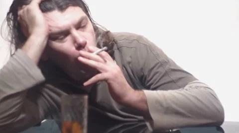 Drunkard smokes sitting at the table Vídeo Stock 35685324