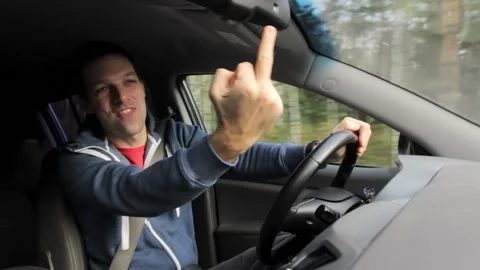 Drunken aggressive man shows middle finger fuck off while driving car Stock Footage 145404809
