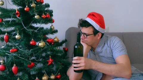 Drunken guy in red cap nerd drinking wine from bottle at Christmas holidays. Stock Footage 136521196