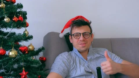 Drunken guy in red cap nerd drinking wine from bottle at Christmas holidays. Video stock 145006597