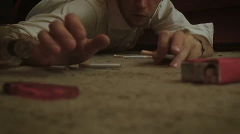 Drunken man crawls on the floor for the cigarette 스톡 동영상 54622709