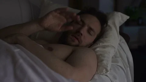 Drunken man sleeping on couch dreaming something bad, having hiccups in sleep Stock Footage 84878284