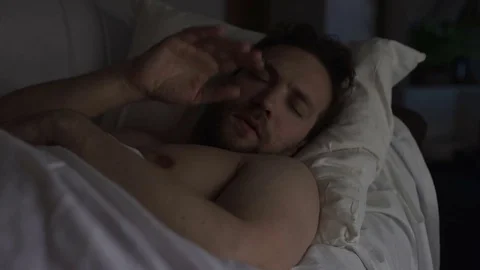 Drunken man sleeping on couch dreaming something bad, having hiccups in sleep Stock Footage 84886818