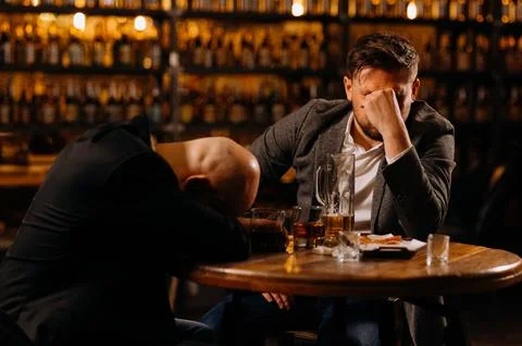 Drunken men sleeping on a table in a pub after work. friends, drink alcohol Stock Photos