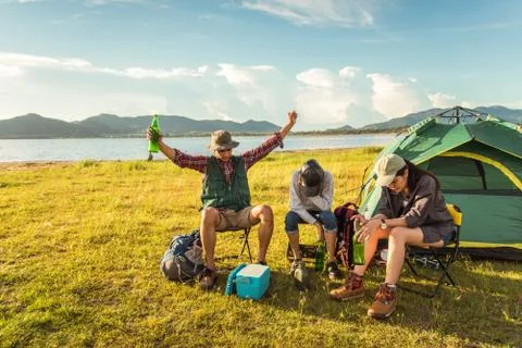 Drunken tourists doing party while camping and picnic in meadow field. Mounta 写真素材