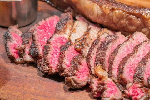 Dry-aged marble beef steak Tomahawk on wooden board with spices. Close-up, di Stock Photos