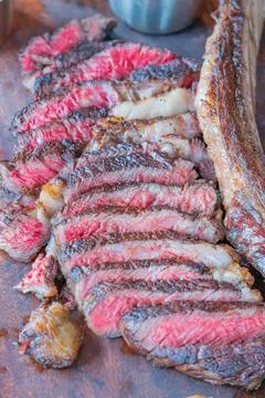 Dry-aged marble beef steak Tomahawk on wooden board with spices. Close-up, di Stock Photos