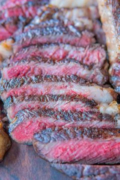 Dry-aged marble beef steak Tomahawk on wooden board with spices. Close-up, di Stock Photos