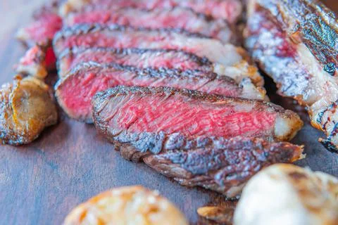 Dry-aged marble beef steak Tomahawk on wooden board with spices. Close-up, di Stock Photos
