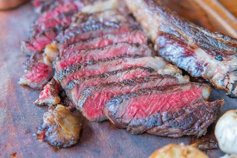 Dry-aged marble beef steak Tomahawk on wooden board with spices. Close-up, di Stock Photos