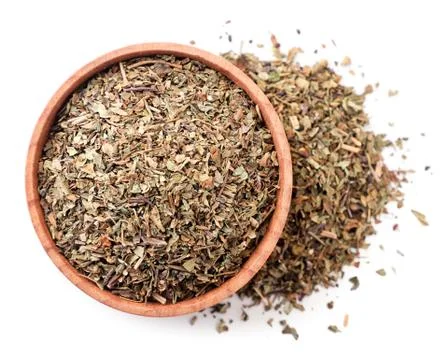 Dry basil in a plate on a white background, isolated. The view from top Stock Photos