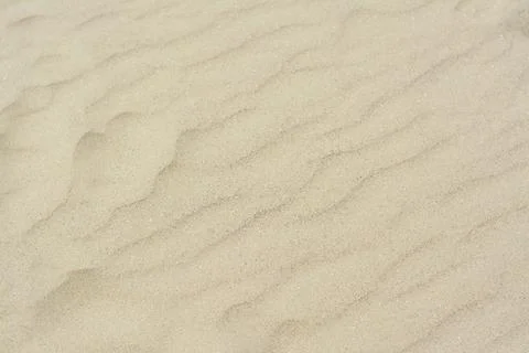 Dry beach sand with wave pattern as background Stock Photos