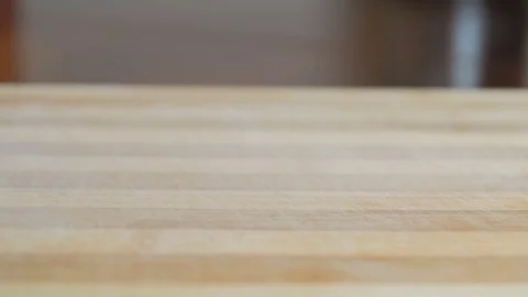 Dry black tea leaves falling on a wooden surface Stock Footage